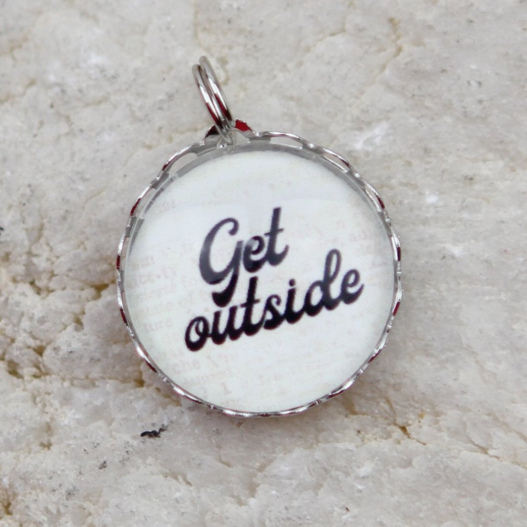 Silver round charm that says Get Outside